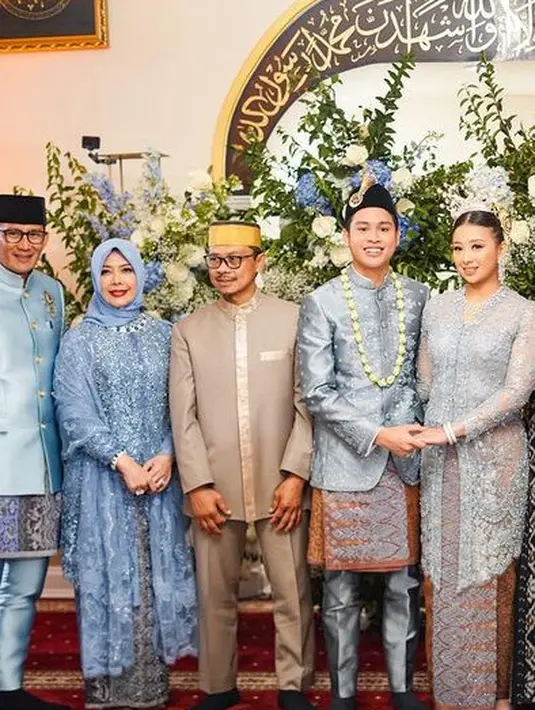 Sandiaga tampil mengenakan jas warna biru berbros serasi dengan celananya, lengkap menggunakan peci hitamnya. Serta kain yang dikenakan di atas celananya.  [@sandiuno]