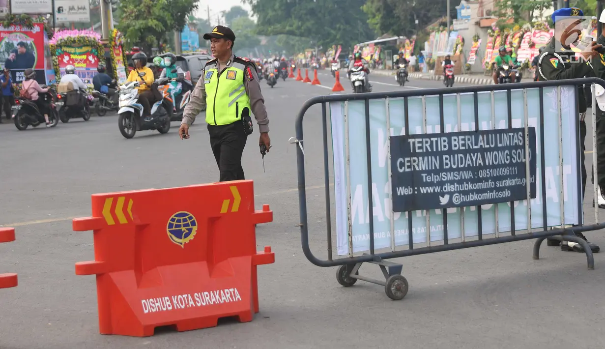 Petugas kepolisian melakukan pengalihan arus lalu lintas di Jalan Letjen Suprapto, Solo, Rabu (8/11). Jalan menuju gedung Graha Saba akan dialihkan dan ditutup selama proses pernikahan Kahiyang Ayu dan Bobby Nasution. (Liputan6.com/Angga Yuniar)