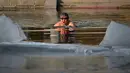 Seorang pria berenang di sungai yang sebagian membeku di Beijing, China (10/1). Akibat membeku, Sungai ini menjadi objek wisata dadakan. (AFP Photo/Wang Zhao)