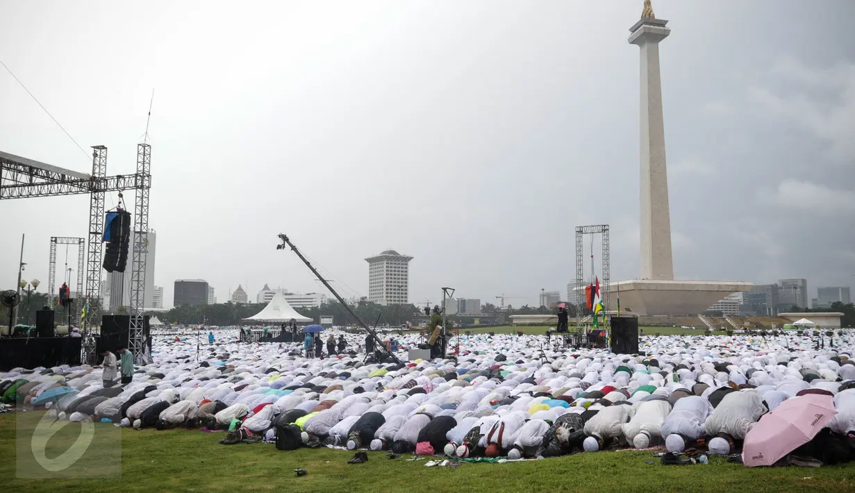 Massa aksi damai 2 Desember bersujud saat menunaikan ibadah salat Jumat di Monas, Jakarta, Jumat (2/12). Meski hujan mengguyur, massa tetap bertahan di saf masing-masing dan melangsungkan salat Jumat bersama-sama. (Liputan6.com/Faizal Fanani)