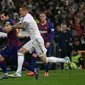 Megabintang Barcelona, Lionel Messi, berebut bola dengan pemain Real Madrid, Toni Kroos pada lanjutan pertandingan La Liga di Santiago Bernabeu, Minggu (2/3/2020).  Real Madrid membungkam Barcelona 2-0 dan merebut puncak klasemen dari Barcelona. (AP/Andrea Comas)