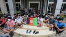 Pengungsi Afghanistan mengibarkan bendera negaranya untuk menunjukkan identitasnya di sebuah kamp pengungsi di Bekasi, Jawa Barat (20/8/2021). Mereka tidak bersedia kembali ke negaranya, terutama setelah Taliban mengambil alih kekuasaan dari pemerintahan Presiden Ashraf Ghani. (AFP/Bay Ismoyo)