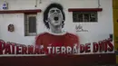 Sebuah mural dari mendiang bintang sepak bola Diego Maradona menutupi dinding dekat stadion Argentinos Juniors di Buenos Aires, Argentina, Selasa, (23/112021). Peringatan pertama kematian Maradona digelar pada 25 November 2021. (AP Photo/Rodrigo Abd)