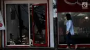 Seorang wanita melintasi unit rumah toko (ruko) yang rusak akibat kebakaran di kawasan Jalan Sabang, Kebon Sirih, Jakarta Pusat, Minggu (8/10). Lokasi kebakaran dijalan raya sempat menyebabkan kemacetan. (Liputan6.com/Angga Yuniar)