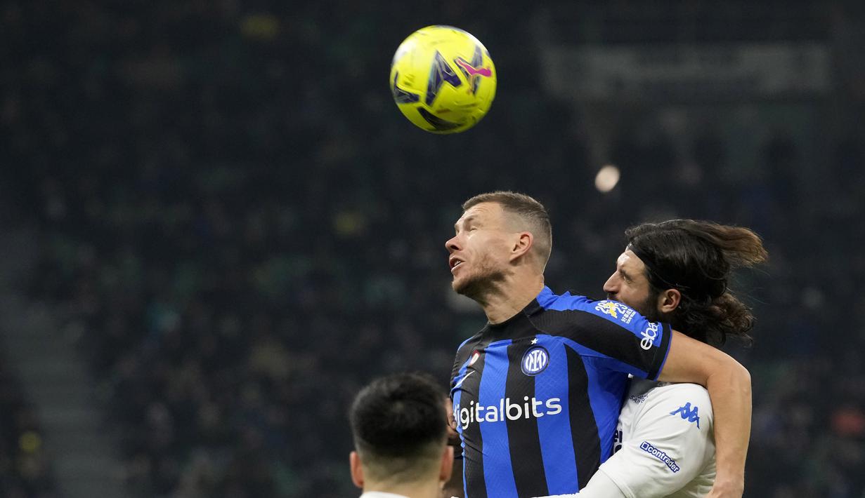<p>Penyerang Inter Milan, Edin Dzeko berebut bola udara dengan pemain Empoli, Sebastiano Luperto pada pertandingan lanjutan Liga Italia di stadion San Siro di Milan, Italia, Selasa (24/1/2022). Inter Milan tumbang atas Empoli dengan skor 0-1. (AP Photo/Luca Bruno)</p>