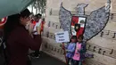 Dua anak berfoto di depan gambar Garuda Pancasila saat mengikuti acara "Untukmu Indonesia" di lapangan Monas, Jakarta, Sabtu (28/4). (Liputan6.com/Arya Manggala)
