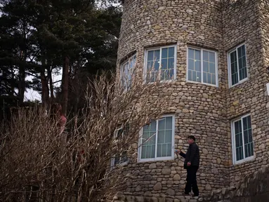 Pengunjung berdiri di luar vila yang dikenal sebagai Kastil Hwajinpodi di Pantai Hwajinpo, Korea Selatan, (19/2). Villa ini merupakan tempat liburan mendiang pendiri Korea Utara Kim Il Sung. (AP Photo/Jae C. Hong)