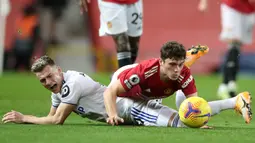 Gelandang Leeds United, Ezgjian Alioski (kiri) dan gelandang Manchester United, Daniel James, terjatuh usai perebutan bola dalam laga lanjutan Liga Inggris 2020/21 pekan ke-14 di Old Trafford Stadium, Minggu (20/12/2020). Leeds United kalah 2-6 dari Manchester United. (AFP/Nick Potts/Pool)