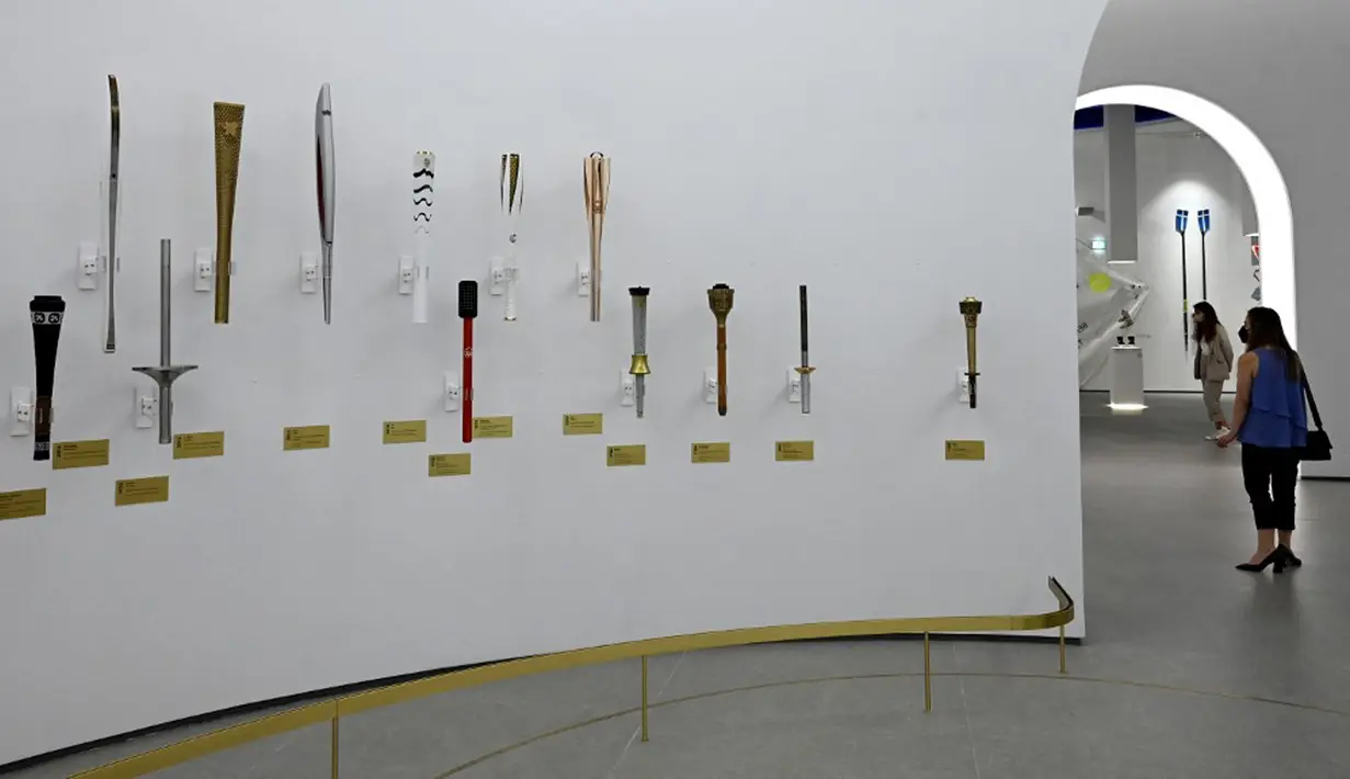 Orang-orang melihat pameran di Museum Olimpiade Athena yang baru pada 25 Mei 2021. Kompleks dibuka untuk umum pada 14 Mei setelah berulang kali menunda peresmiannya karena COVID-19. (Aris MESSINIS/AFP)