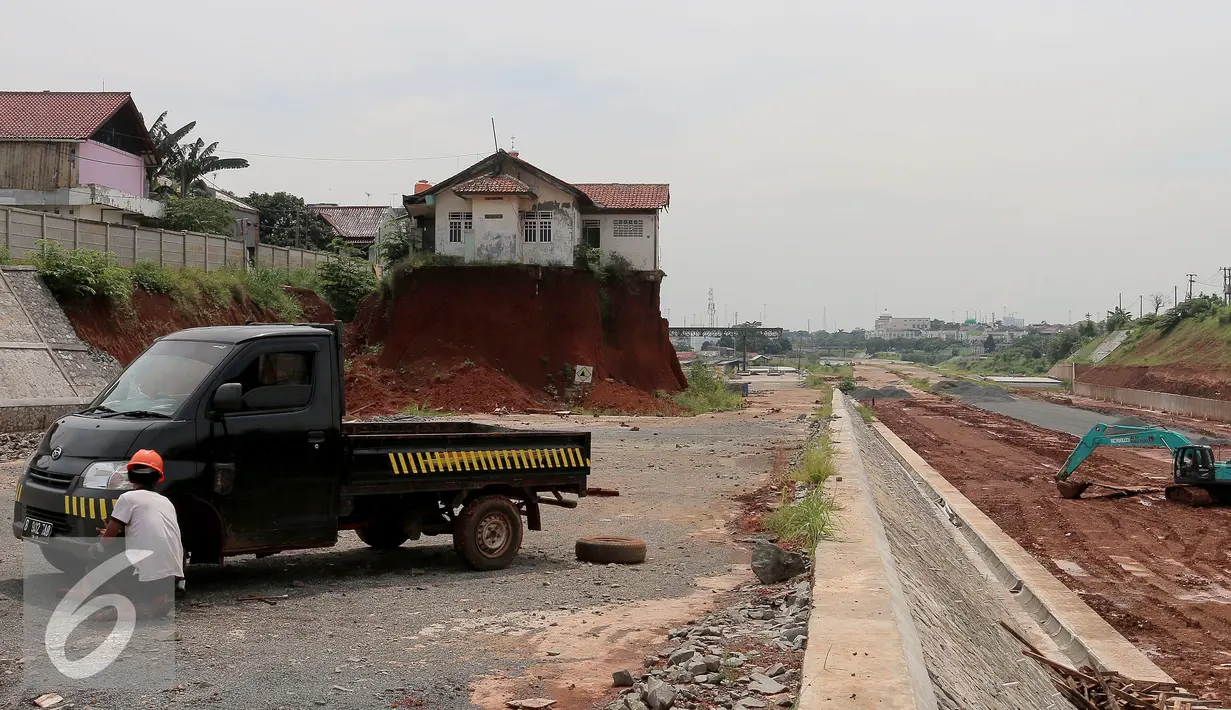 Pekerja mengganti ban di samping Musala yang masih berdiri di lokasi pembangunan proyek Tol Cinere-Jagorawi (Cijago) seksi II di Depok, Jawa Barat, Selasa (1/11). (Liputan6.com/Johan Tallo)