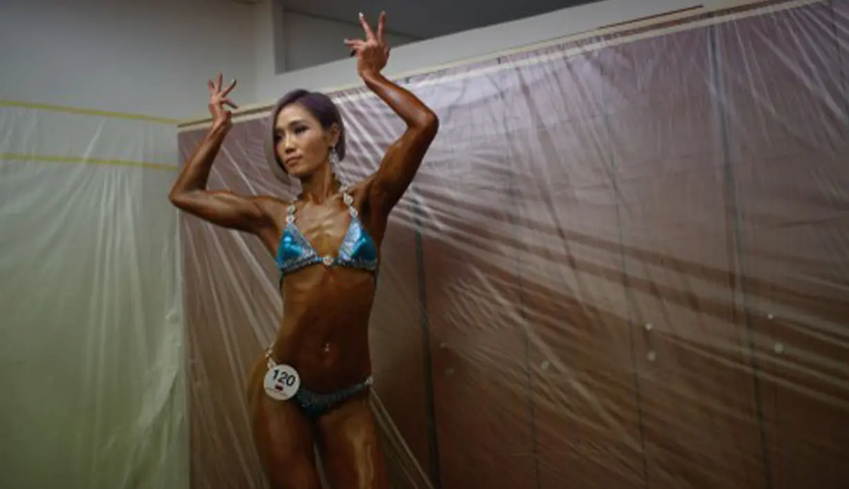 Seorang atlet Binaraga mencoba aneka gaya jelang “Miss Sport Model 2015” di Korea Selatan, Minggu (10/5/2015). 550 atlet binaraga Korea Selatan bersaing untuk mendapat kesempatan berlaga di tingkat internasional. (AFP Photo/Ed Jones)