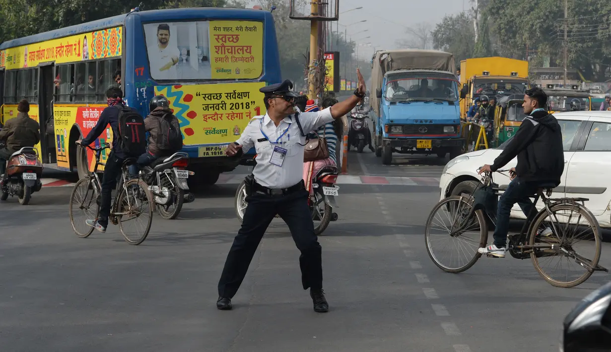 Polisi lalu lintas India Ranjeet Singh melakukan tarian "moonwalking" saat mengarahkan lalu lintas di persimpangan Indore, India (22/12). Cara Ranjeet Singh mengatur lalu lintas menjadi pusat perhatian warga sekitar. (AFP Photo/Indranil Mukherjee)