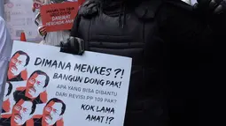 Massa Aliansi Koalisi Masyarakat Peduli Kesehatan (KOMPAK) mengenakan kostum Anonymous saat menggelar aksi di depan Kementerian Kesehatan, Jakarta, Kamis (26/11/2020). (Liputan6.com/Herman Zakharia)