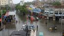 Orang-orang melewati jalan yang banjir setelah hujan monsun lebat, di Hyderabad, Pakistan, Rabu (24/8/2022). Hujan deras telah memicu banjir bandang dan mendatangkan malapetaka di sebagian besar Pakistan sejak pertengahan Juni, menyebabkan 903 orang tewas dan sekitar 50.000 orang kehilangan tempat tinggal, kata badan bencana negara itu. (AP Photo/Pervez Masih)