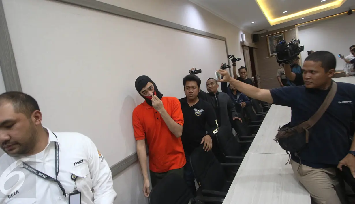 Tersangka pemukulan jurnalis TV, Kashira Uozumi, dibawa petugas saat jumpa pers di Mapolres Metro Jakarta Selatan, Kamis (13/4). Polisi menyatakan pria yang melakukan pemukulan terhadap jurnalis NET TV, positif narkoba. (Liputan6.com/Immanuel Antonius)