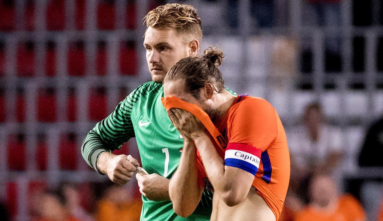 Pemain Belanda, Daley Blind menutup wajah saat berjalan bersama Jeroen Zoet saat timnya kalah dari Yunani pada laga persahabatan di Stadion Philips, Eindhoven, (2/9/2016) dini hari WIB. (AFP/ANP/Koen van Weel/Netherlands OUT)