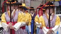 Penampil mengenakan seragam penjaga tradisional dan masker berdiri selama pemeragaan pembukaan dan penutupan gerbang di Gerbang Sungnyemun di Seoul, Selasa (15/3/2022). Korea Selatan pada hari Selasa melaporkan 293 kematian covid-19 dalam 24 jam terakhir. (AP Photo/Ahn Young-joon)