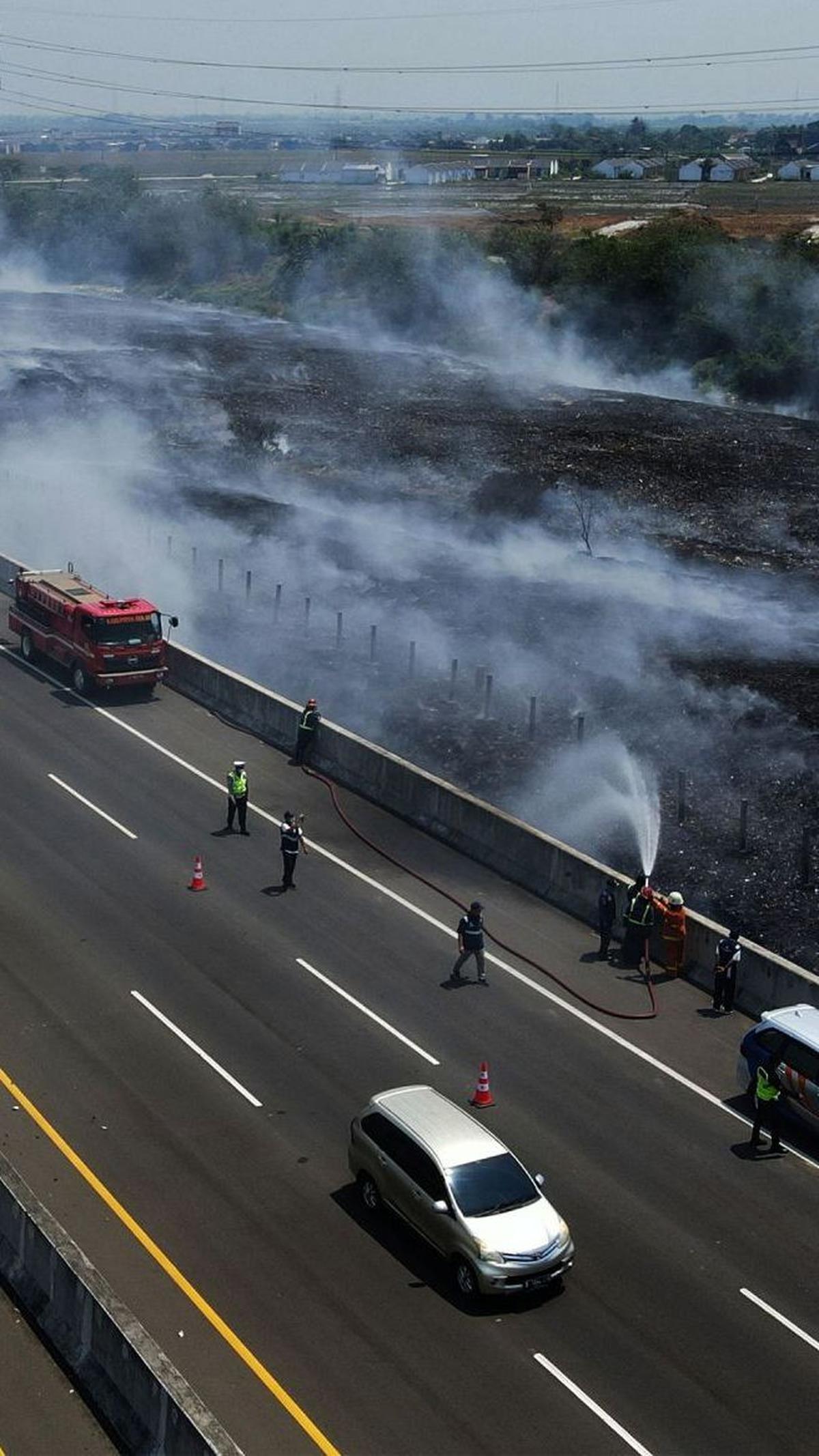 Petugas gabungan saat melakukan pemadaman  asap sisa kebakaran TPS Ilegal di samping Tol Cibitung-Cilincing.