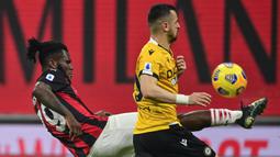 Gelandang AC Milan, Franck Kessie (kiri) berebut bola dengan striker Udinese, Ilja Nestorovski dalam laga lanjutan Liga Italia 2020/21 pekan ke-25 di San Siro Stadium, Rabu (3/3/2021). AC Milan bermain imbang 1-1 dengan Udinese. (AFP/Miguel Medina)