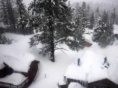 Pandangan udara orang-orang yang bekerja menyekop atap di tengah tumpukan salju dari badai saat ini dan sebelumnya, selama badai musim dingin lainnya di pegunungan Sierra Nevada di Danau Mammoth, California pada 10 Maret 2023. Pegunungan Sierra Nevada di California dilanda hujan salju lebat di ketinggian yang lebih tinggi sehingga meningkatkan tingkat tumpukan salju yang sangat besar menjadi lebih tinggi. (Mario Tama/Getty Images/AFP)