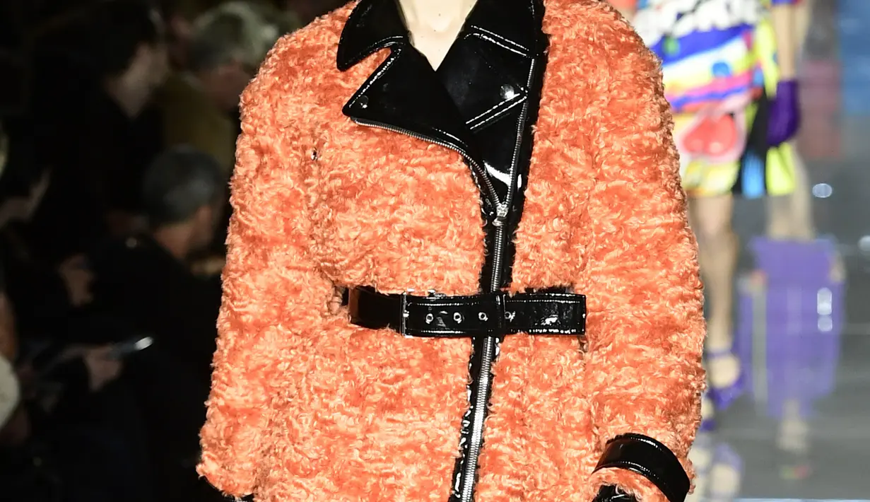 Model AS, Gigi Hadid berjalan mengenakan koleksi terbaru Moschino di panggung runway Milan Fashion Week 2018, Rabu (21/2). Gigi Hadid terlihat dengan koleksi coat warna oranye dengan patent leather trim dan topi yang senada bahannya. (Miguel MEDINA/AFP)