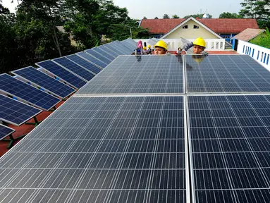 Seorang guru mengajarkan praktek perawatan solar panel kepada siswa kompetensi keahlian Teknik Energi Surya Hidro dan Angin (TESHA) di SMK Negeri 1 Kemang Bogor, Jawa Barat, Kamis (19/5/2022). Solar panel teserbut selain sebagai media pembelajaran siswa juga menghasilkan energi listrik yang digunakan untuk kebutuhan pasokan listrik di lab sekolah tersebut. (merdeka.com/Arie Basuki)