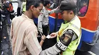 Petugas polisi dari Polsek Sawah Besar memeriksa seorang pria penumpang angkutan umum yang diduga preman saat digelar Operasi Cipta Kondisi di kawasan Pasar Baru, Jakarta, Sabtu (27/11). (Antara)