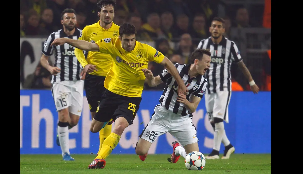 Bek Dortmund, Sokratis Papastathopoulos berusaha merebut bola dengan Stephan Lichtsteiner di leg kedua 16 besar Liga Champions di Stadion Signal Iduna Park, German (18/3/15). Juventus menang 3-0 atas Borussia Dortmund. (Reuters/Ina Fassbender)