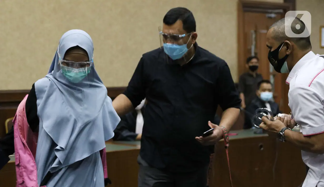 Tersangka dugaan korupsi dan tindak pidana pencucian uang terkait kepengurusan fatwa untuk Djoko Tjandra di Mahkamah Agung, Pinangki Sirna Malasari (kiri) bersiap menjalani sidang di Pengadilan Tipikor Jakarta, Rabu (30/9/2020). Sidang beragenda pembacaan eksepsi. (Liputan6.com/Helmi Fithriansyah)
