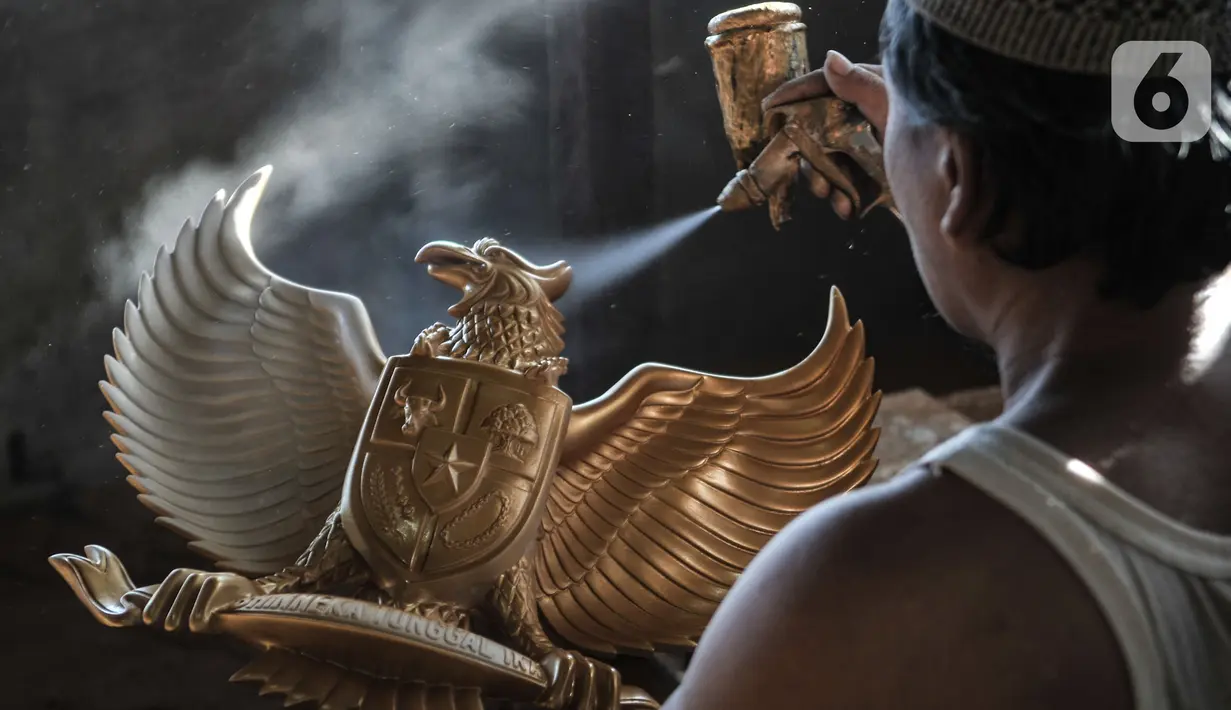 Perajin menyelesaikan proses pewarnaan patung Garuda Pancasila di industri rumahan di Jalan Bali Raya, Jakarta, Kamis (1/10/2020). Perajin menjual patung Garuda Pancasila dengan harga yang dijual berkisar Rp100 ribu-Rp125 ribu per buah. (merdeka.com/Iqbal S. Nugroho)