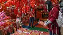 Seorang perempuan melihat dekorasi menjelang Tahun Baru Imlek di Hong Kong pada 26 Januari 2022. Tahun Baru Imlek untuk masyarakat Tionghoa atau China di seluruh dunia pada tahun ini akan jatuh pada tanggal 1 Februari 2022. (Peter PARKS / AFP)