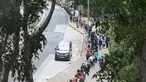 Orang-orang mengantre di stasiun pengumpulan spesimen bergerak untuk pengujian Covid-19 di distrik Tung Chung, Hong Kong pada 10 Februari 2022. Antrean terjadi ketika pihak berwenang bergegas untuk meningkatkan kapasitas pengujian menyusul rekor jumlah infeksi baru yang tinggi. (Peter PARKS / AFP)