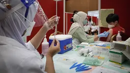 Seorang siswa sekolah menengah menerima dosis vaksin Pfizer terhadap penyakit coronavirus (COVID-19) di pusat vaksin di Shah Alam, Malaysia, Senin (20/9/2021). (AP Photo/Vincent Thian)