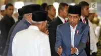 Presiden Joko Widodo atau Jokowi menyalami jemaah salat id saat tiba di Masjid Istiqlal, Jakarta, Rabu (5/6/2019). Jokowi mengenakan setelan jas abu-abu, kemeja putih serta peci hitam. (Liputan6.com/JohanTallo)