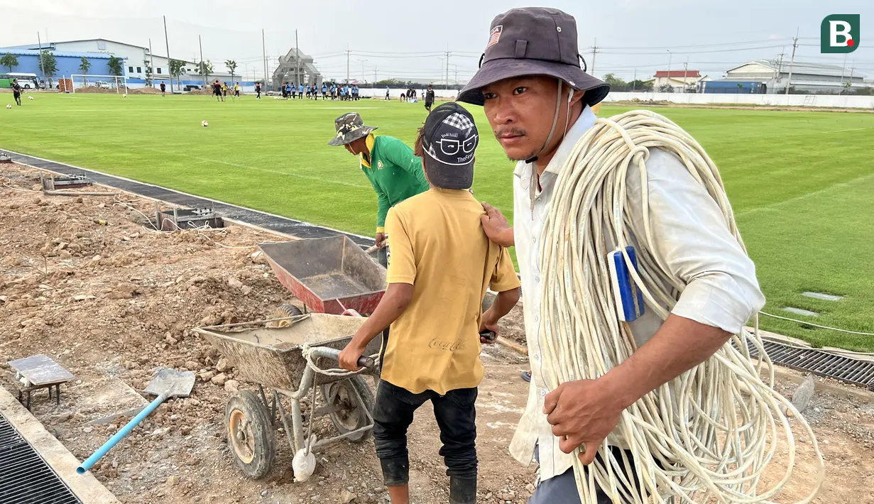 Seorang pekerja bangunan membawa gulungan kabel dalam tahap akhir pembangunan Visakha Training Center milik Visakha FC yang tengah digunakan Timnas Indonesia U-22 menggelar sesi latihan terakhir, Rabu (3/5/2023) jelang menghadapi Myanmar pada laga kedua Grup A SEA Games 2023 yang akan digelar Kamis, 4 Mei 2023. (Bola.com/Gregah Nurikhsani)