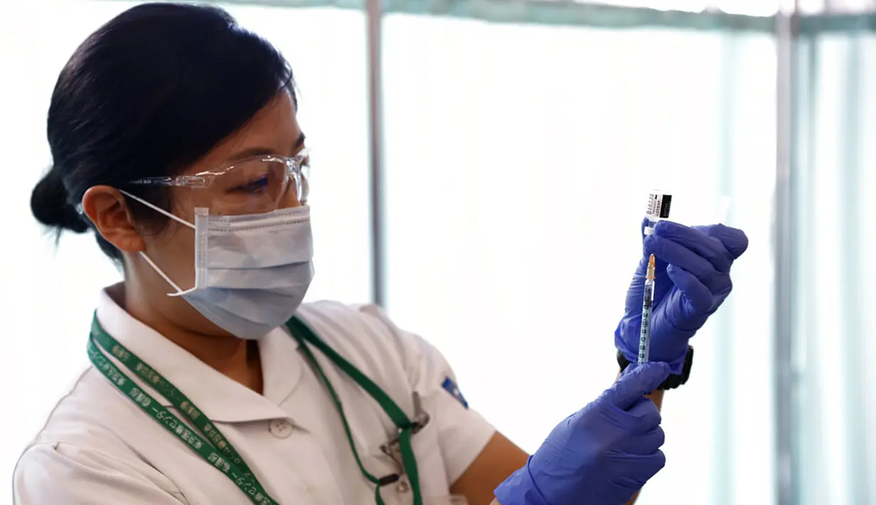 Seorang pekerja medis mengisi jarum suntik dengan dosis vaksin Pfizer-BioNTech COVID-19 di Tokyo Medical Center, Tokyo, Jepang, Rabu (17/2/2021). Jepang memulai kampanye vaksinasi COVID-19 dengan suntikan COVID-19 pertama diberikan kepada petugas kesehatan. (Behrouz Mehri/Pool Photo via AP)
