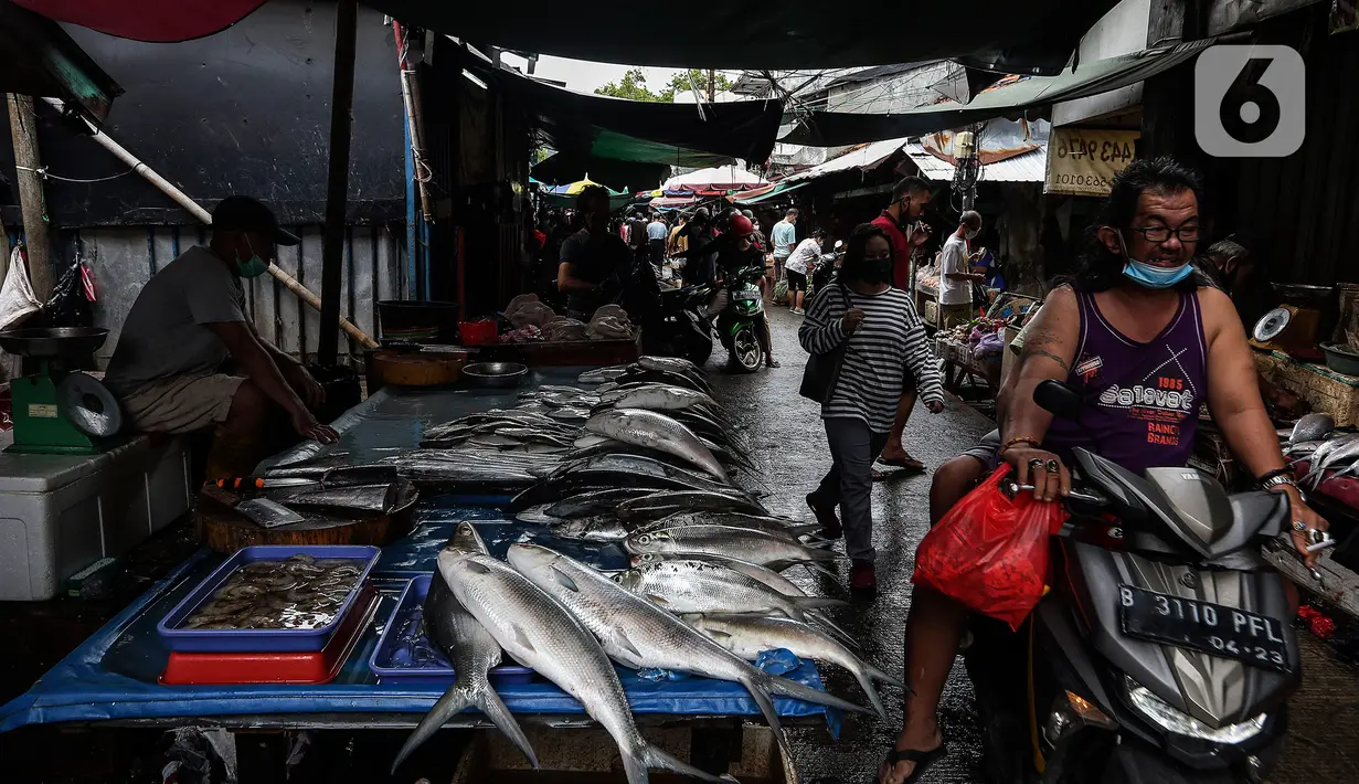 Pedagang ikan bandeng, salah satu makanan khas Imlek, menunggu pembeli di Kawasan Petak Sembilan, Glodok, Jakarta, Minggu (7/2/2021). Kelenteng tua seperti Toa Se Bio sebagai penanda bahwa komunitas Tionghoa di Glodok telah hidup dari generasi ke generasi. (Liputan6.com/Johan Tallo)