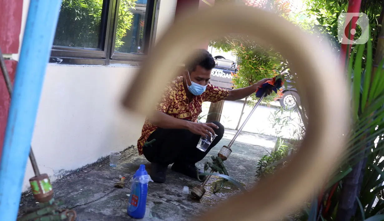 Petugas UPT Disperindagkop UKM Kota Tangerang memperbaiki alat ukur timbangan saat sidak di Kecamatan Larangan, Kota Tangerang, Banten, Kamis (2/12/2021). Petugas menyarankan pemilik alat ukur timbangan untuk memperbaiki jika ada kerusakan. (Liputan6.com/Angga Yuniar)