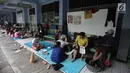Aktivitas warga yang rumahnya terendam banjir mengungsi di Gedung SMP Negeri 26, Jalan Kebon Pala, Kampung Melayu, Jatinegara, Jakarta Timur, Selasa (6/2). Sebanyak 42 KK mengungsi di tempat tersebut. (Liputan6.com/Arya Manggala)