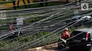 Kendaraan melintas di bawah kabel listrik dan kabel optik yang terlihat semrawut di kawasan Taman Puring, Jakarta, Jumat (3/7/2020). Tidak ada aturan yang baku membuat satu tiang listrik bisa digunakan berbagai kabel baik itu listrik ataupun optik dari berbagai provider. (Liputan6.com/Johan Tallo)