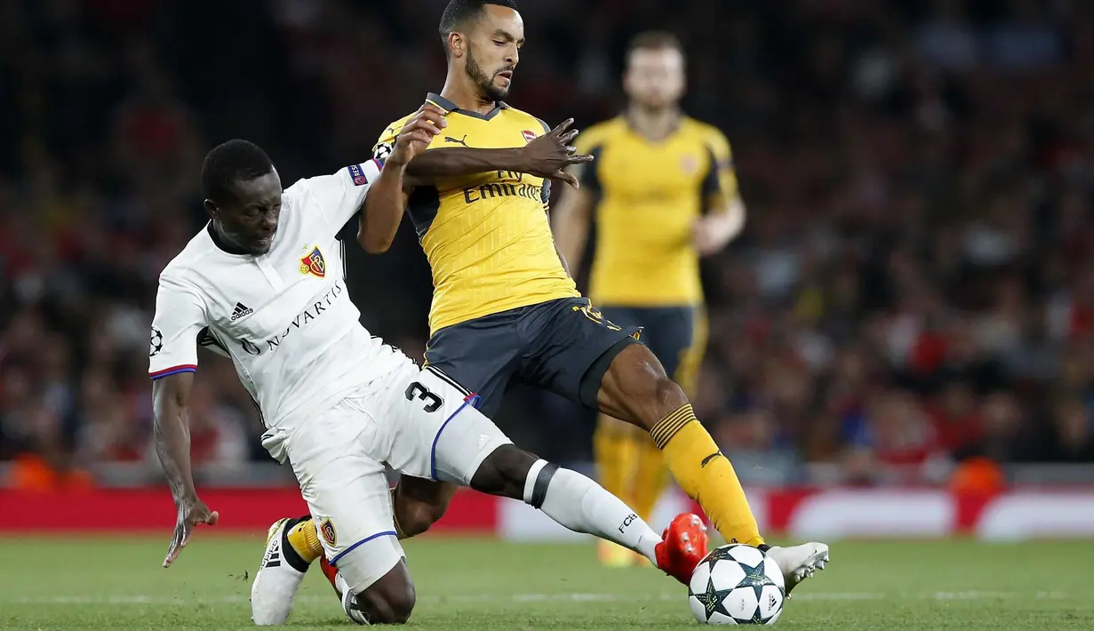 Pemain Basel, Adama Traore (kiri) berebut bola dengan pemain Arsenal, Theo Walcott pada laga grup A Liga Champions di Emirates stadium, London, Kamis (29/9/2016)dini hari WIB. Arsenal menang 2-0. (AP/Alastair Grant)