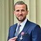 Penyerang Tottenham Hotspur sekaligus kapten Timnas Inggris, Harry Kane mendapatkan gelar MBE (Member of the Order of the British Empire) atas perannya membawa The Three Lions ke semifinal Piala Dunia 2018 di Rusia. Ia dianggap berjasa mengangkat kembali pamor Timnas Inggris. (AFP/Pool/Victoria Jones)