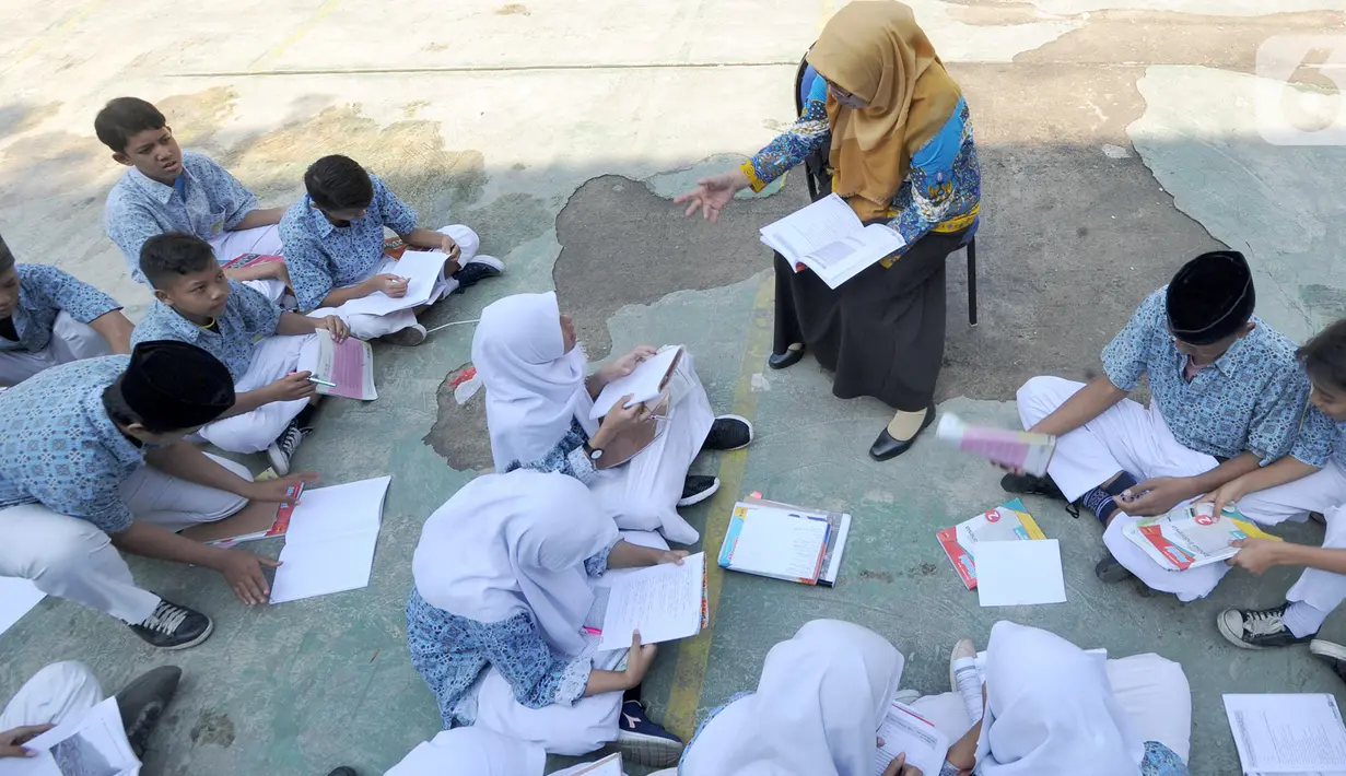 Siswa kelas VIII belajar mata pelajaran Sejarah Kebudayaan di halaman sekolah Mts. Hidayatul Umam di Cinere, Depok, Kamis (7/11/2019). Kementerian PPPA melaksanakan kegiatan hari belajar di luar kelas yang serentak di seluruh Indonesia pada Kamis (7/11). (merdeka.com/Arie Basuki)