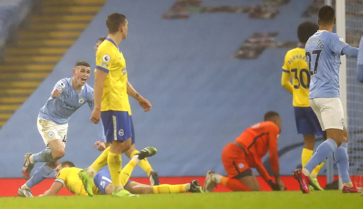 Pemain Manchester City Phil Foden (kiri) melakukan selebrasi usai mencetak gol ke gawang Brighton and Hove Albion pada pertandingan Liga Inggris di Etihad Stadium, Manchester, Inggris, Rabu (13/1/2021). Manchester City menang 1.0. (Martin Rickett /Pool via AP)