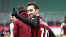 Pemain AC Milan, Hakan Calhanoglu, merayakan kemenangan atas Torino pada laga Coppa Italia di Stadion San Siro, Selasa (12/1/2021). AC Milan menang adu penalti dengan skor 5-4. (AP/Antonio Calanni)