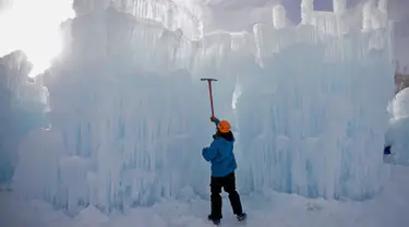 Seorang pekerja memahat dinding es saat mebuat kastel atau Istana Es di Midway, Utah (27/12). Nantinya pengunjung akan dapat menikmati Istana Es yang terdiri dari labirin, ngarai atau lembah, terowongan dan air mancur. (AP/Rick Bowmer)