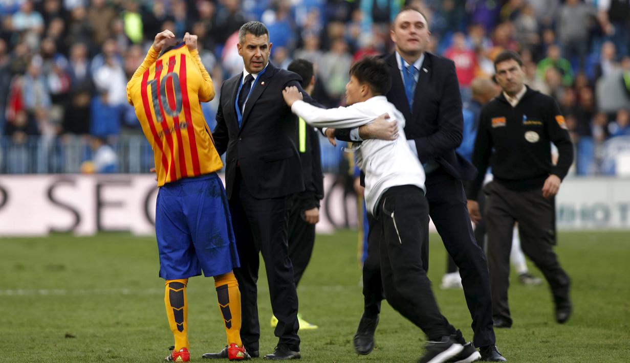 Seorang penggemar berusaha mendekati bintang Barcelona, Lionel Messi, setelah laga melawan Malaga dalam lanjutan La Liga Spanyol di Stadion La Rosaleda, Malaga, Sabtu (23/1/2016). (Reuters/Jon Nazca)