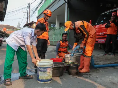 Warga membawa wadah untuk mengambil air bersih dari mobil tangki BPBD DKI Jakarta di Gang H Soleh, Cilandak Timur, Jakarta Selatan, Senin (21/9/2026). Sebanyak 5.000 liter air didistribusikan untuk memenuhi kebutuhan warga terdampak kekeringan. (KLY/Budy Santoso)