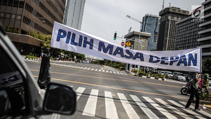 Massa aksi yang tergabung dalam gerakan masyarakat non partisan #BersihkanIndonesia  membentangkan spanduk saat aksi teatrikal di lintasan penyeberangan orang atau Pelican crossing di Jakarta, Kamis (20/12). (Liputan6.com/Faizal Fanani)