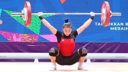 Lifter putri Jawa Barat, Windy Cantika Aisah, saat beraksi pada nomor 49 kg di PON XX Papua di Auditorium Universitas Cendrawasih Jayapura, Rabu (6/10/2021). Cindy meraih medali emas dengan total angkatan 192kg. (Foto: PB PON XX PAPUA/Dadang Tri)